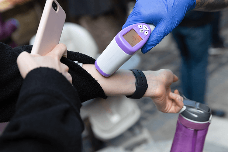 Fever measurement on an employee with scanning gun on wrist